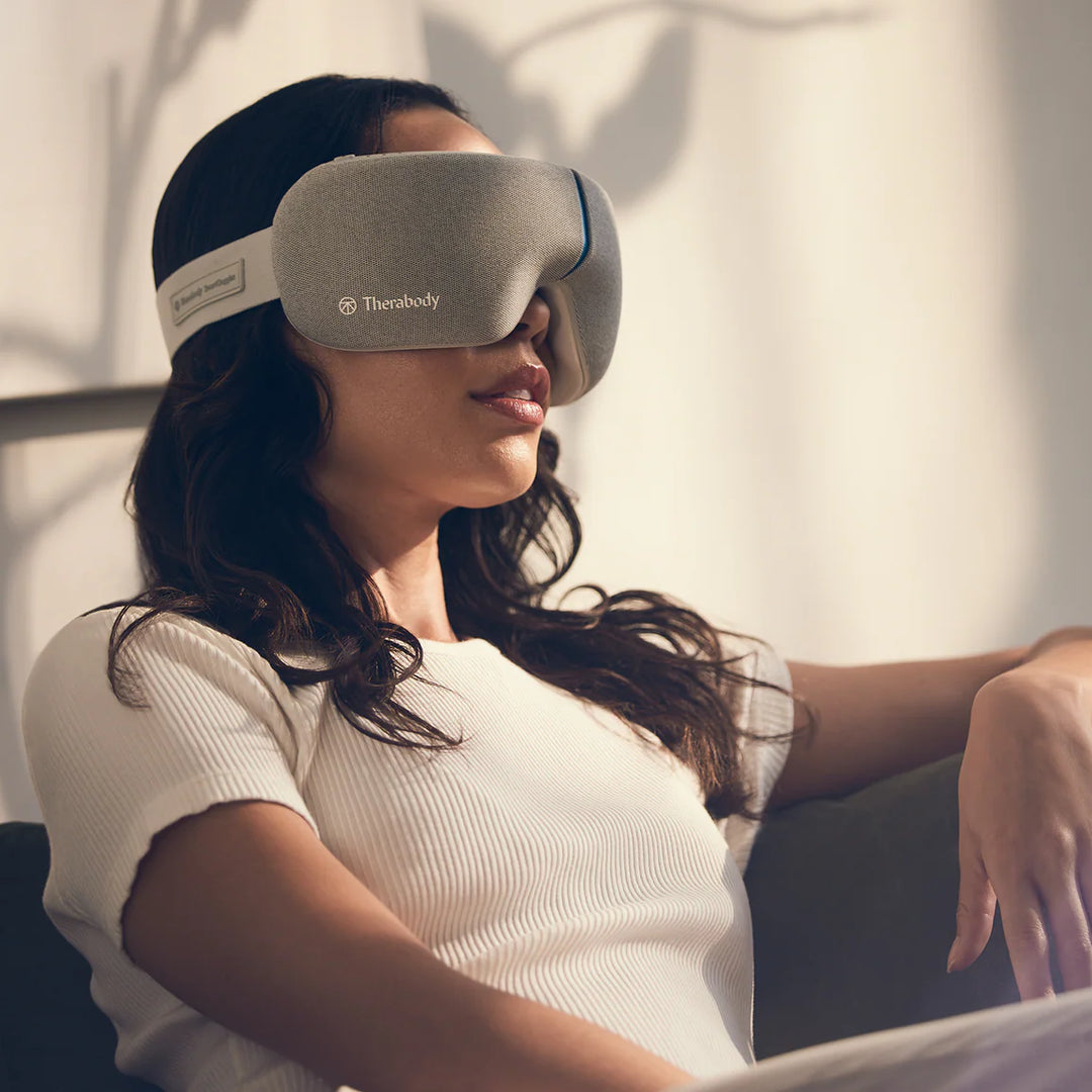 Woman wearing a TheraBody eye mask in a relaxed setting