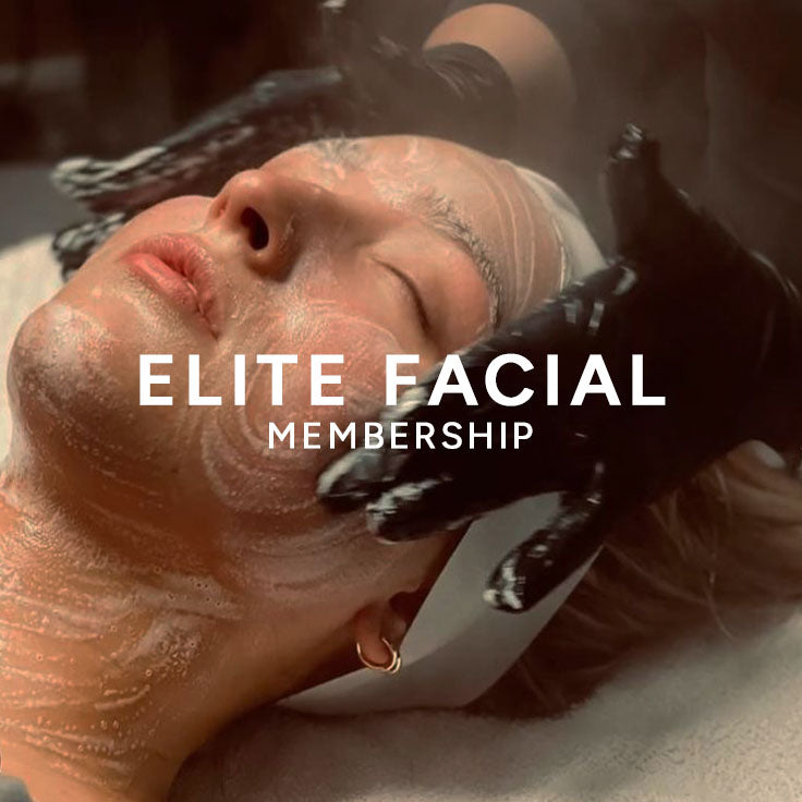 A close-up of a person lying down with a white facial mask or cream on their face, wearing black gloves, with large white text reading 'ELITE FACIAL MEMBERSHIP' across the center.