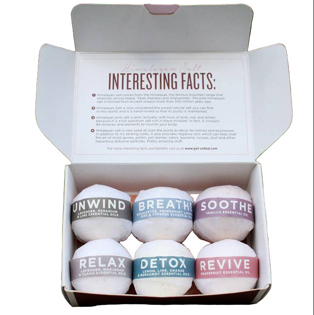 Set of six bath bombs in a box with labels on a white background