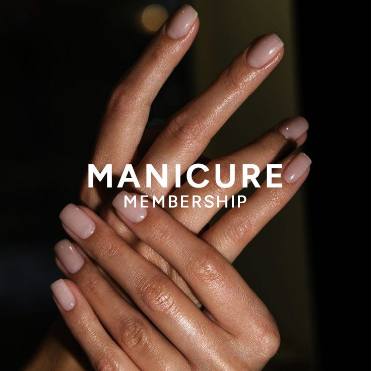 A close-up of crossed hands with a glossy nude manicure, overlaid with the text 'MANICURE MEMBERSHIP' in white. The background is dark and softly blurred.